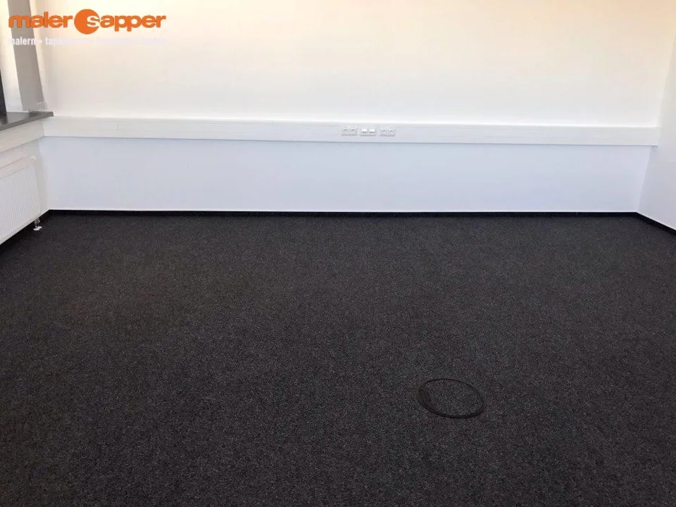 Dunkler Teppichboden in einem hellen Raum mit Heizkörper
