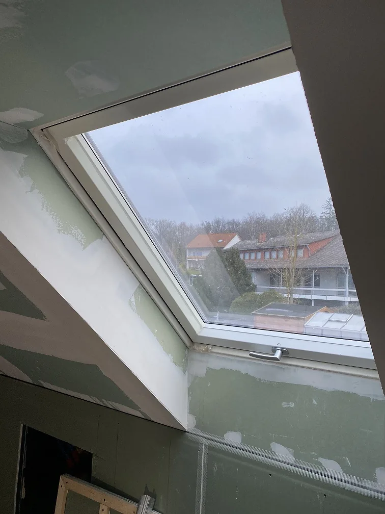 Dachschräge mit eingefasstem Dachfenster während des Ausbaus
