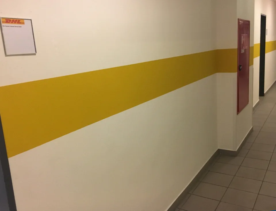 Flur mit gelbem Farbstreifen auf den Wänden